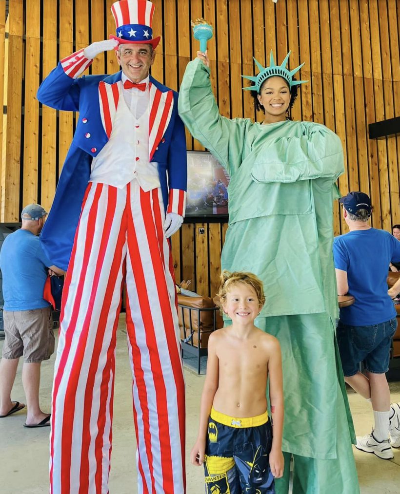 little boy posing with Uncle Sam and Statue of Liberty (on stilts)