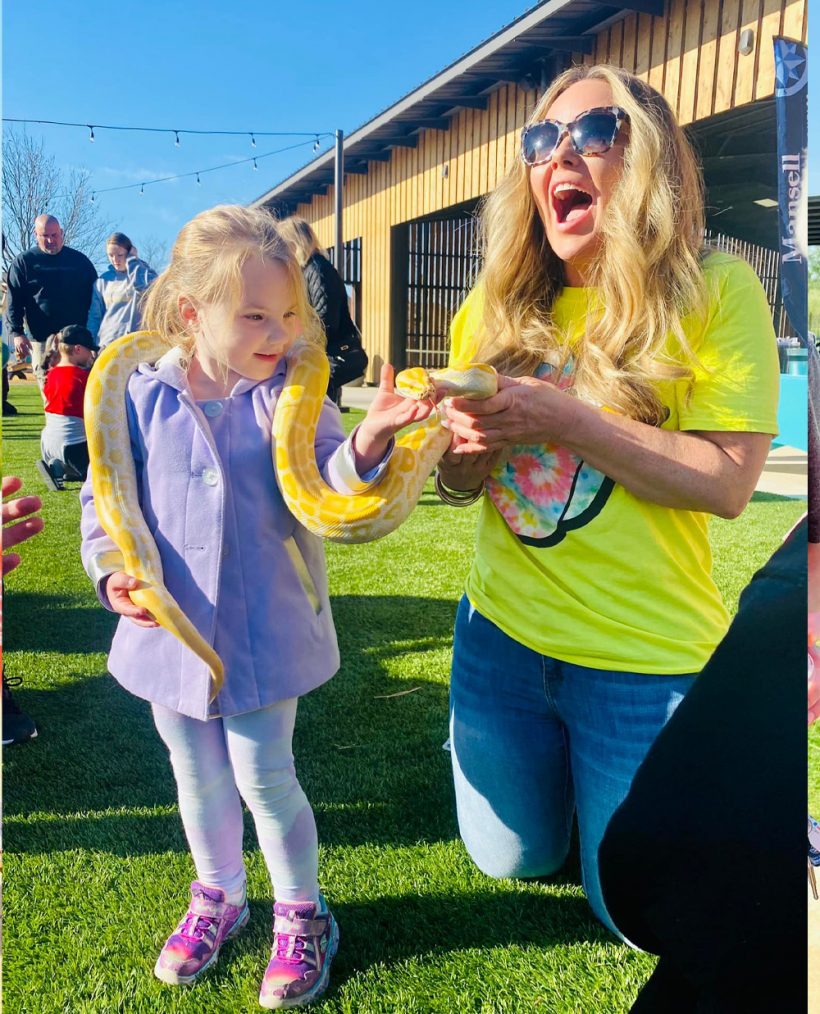 little girl with big yellow snake around her neck