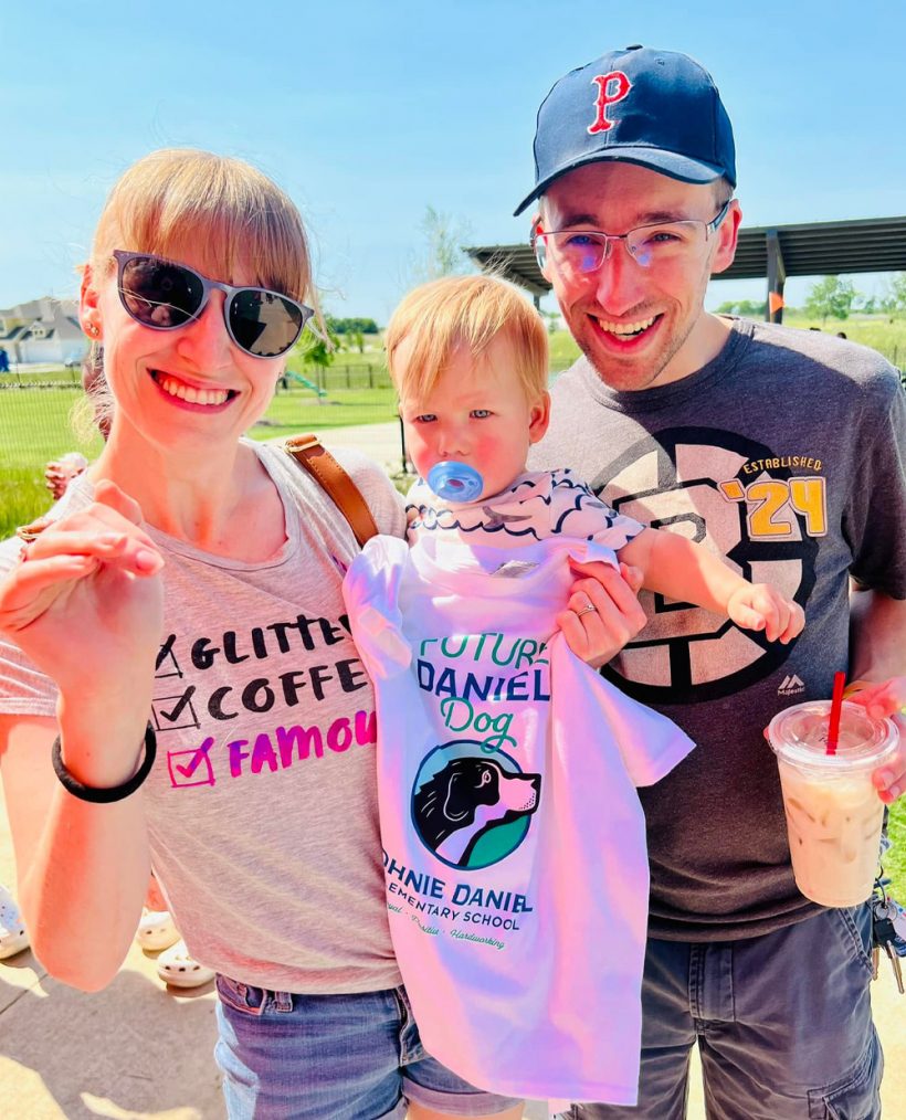 young family - little girl posing with Johnie Daniel Elementary t-shirt