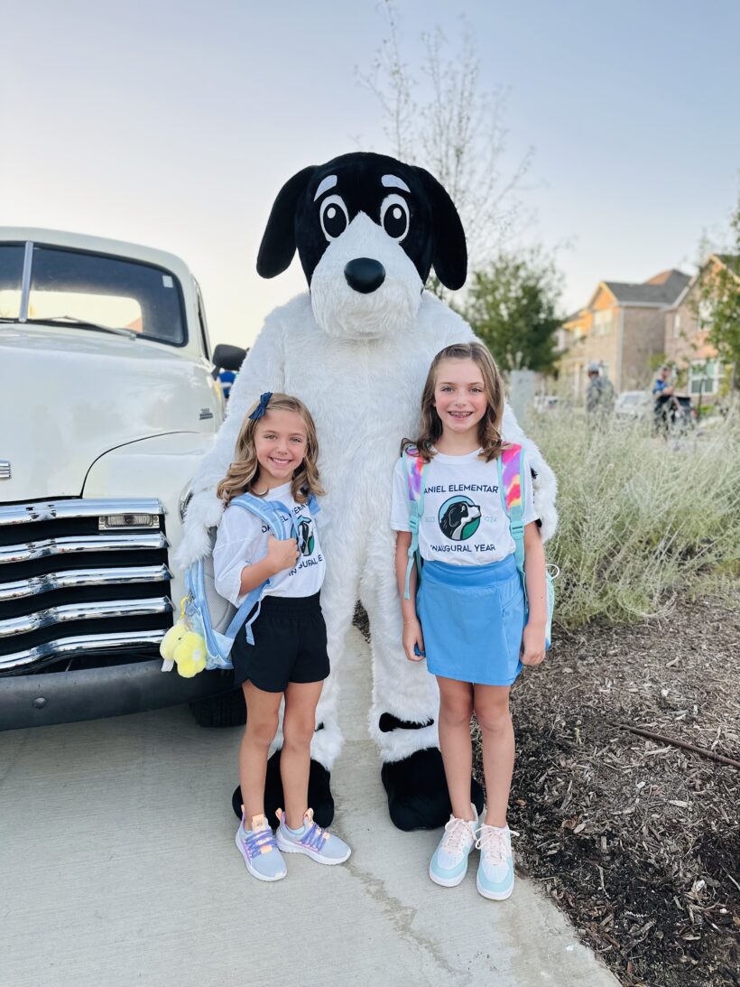 Two schoolchildren with a school mascot