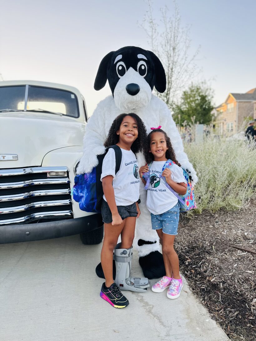 Two school children with a dog mascot